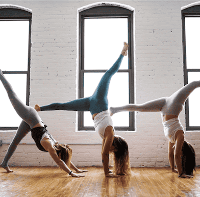 Three women doing yoga poses in a yoga studio