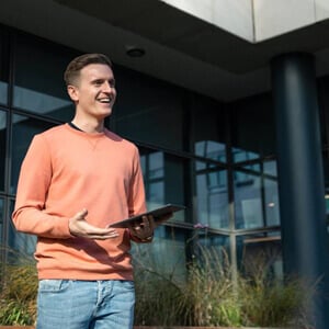 Young marketing professional speaking in courtyard with tablet in hand